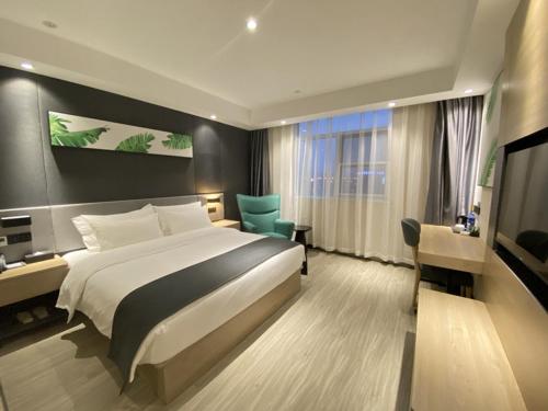 um quarto de hotel com uma cama, uma secretária e uma cadeira em Thank Inn Plus Yancheng Sheyang Dayang Road em Sheyang