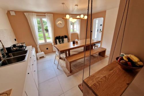 - une cuisine avec une table et une balançoire dans l'établissement Les Jardins de Rosie, à Arthies