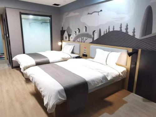 two beds in a bedroom with a wall with a mural at Thank Inn Plus Korla Saybag Market in Korla