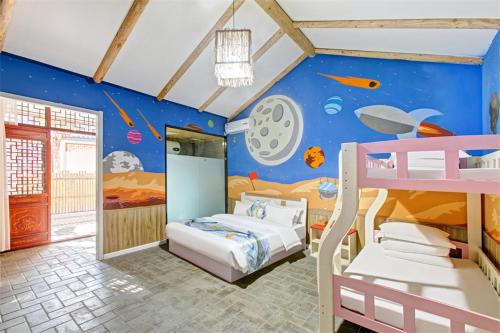ein Kinderzimmer mit 2 Etagenbetten und einem Wandbild in der Unterkunft Feronia Hotel Changzhi Huguan Happy Taihang Valley in Huguan