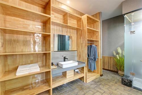 ein Badezimmer mit Holzregalen, einem Waschbecken und einer Dusche in der Unterkunft Feronia Hotel Changzhi Huguan Happy Taihang Valley in Huguan