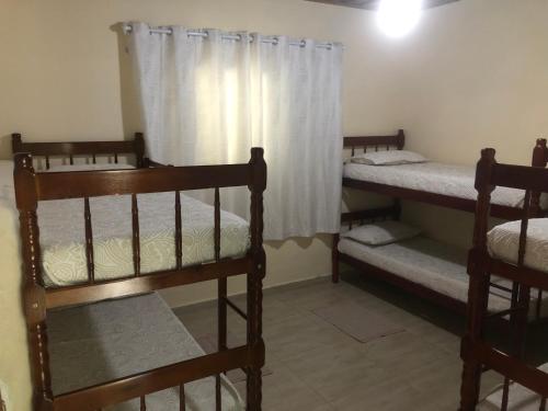 ein Zimmer mit zwei Etagenbetten und einem Fenster in der Unterkunft Casa Ampla e Confortável a 10 minutos Praia Ubatumirim Cambuca in Ubatuba
