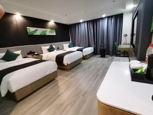 una habitación de hotel con 3 camas en una habitación en Thank Inn Plus Aksu Kuqa Xingfu Road, en Kuqa