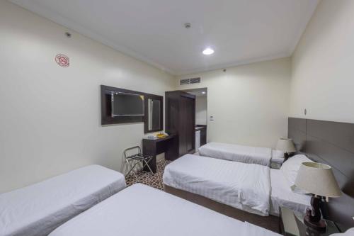 a hotel room with two beds and a television at Abdul Hafez Al Humaidan Hotel in Makkah