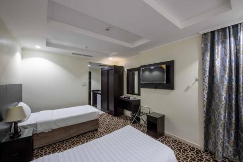 a hotel room with two beds and a mirror at Abdul Hafez Al Humaidan Hotel in Makkah