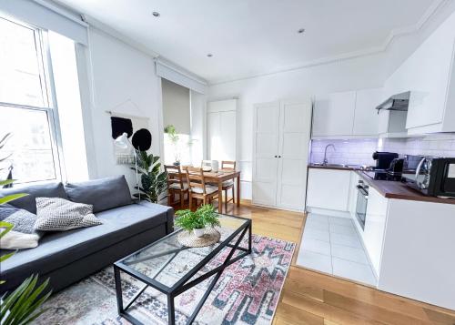 a living room with a couch and a kitchen at Baker Street Central Apartments in London