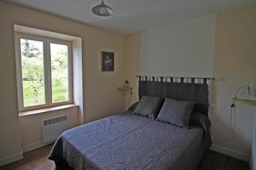 1 dormitorio con cama y ventana en L' ecurbie, en Coussac-Bonneval