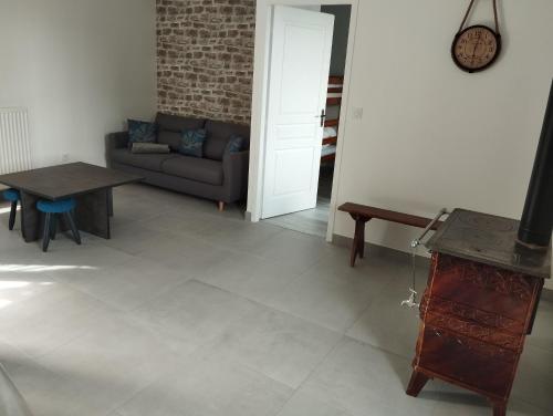 a living room with a couch and a table at Maison au calme avec vue étang in Clessé