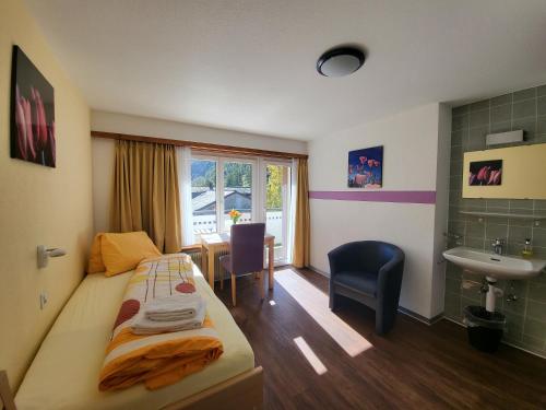 ein Hotelzimmer mit einem Bett und einem Waschbecken in der Unterkunft Pension Heino in Saas-Grund