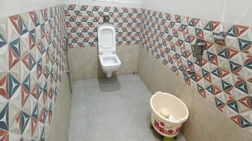 a small bathroom with a toilet and tiles on the walls at Hotel King Safire in Port Blair