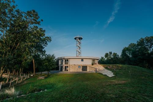 un bâtiment avec une tour au-dessus d'un champ dans l'établissement Apartmány Kurovický lom, à Kurovice