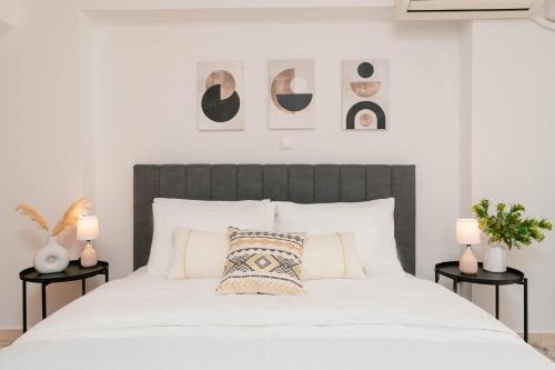 een slaapkamer met een groot wit bed en 2 nachtkastjes bij Phaedrus Living: Cozy Flat Koukaki in Athene