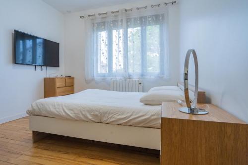 une chambre blanche avec un lit et une télévision dans l'établissement Room in Toulouse - Studio 2 proche Airbus à TOULOUSE ST Martin du Touch, à Toulouse
