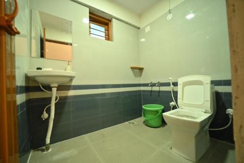 a bathroom with a toilet and a sink at Coorg HomeStay Resort in Kushālnagar