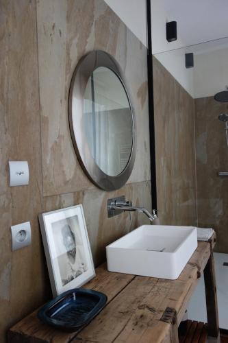 een badkamer met een witte wastafel en een spiegel bij la maison haute in Toucy