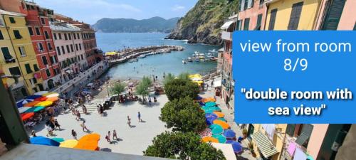 a view from a balcony of a town with a beach at Albergo Barbara in Vernazza