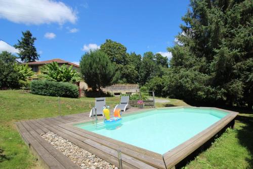 une piscine avec deux chaises longues et une piscine dans l'établissement Le four a pain d'ermance, à Chaillac-sur-Vienne