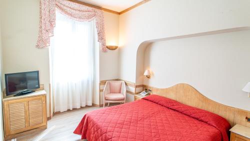 a bedroom with a red bed and a television at Bobby Executive in Sanremo