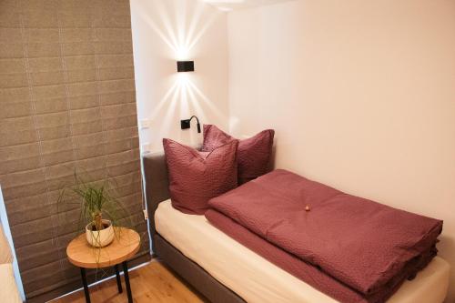 ein kleines Schlafzimmer mit einem Bett mit roten Kissen in der Unterkunft Das Gschossmann in Saalbach-Hinterglemm
