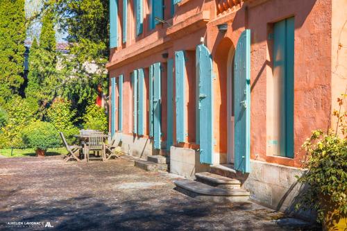 a building with blue windows and a picnic table outside at Chateau Pont Saint-Martin in Léognan