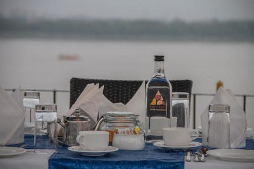 a table with a bottle of wine and a table with plates and cups at Amritara Suryauday Haveli in Varanasi