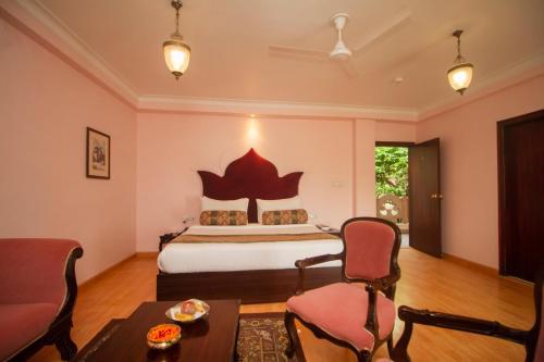 a bedroom with a bed and a table and chairs at Amritara Suryauday Haveli in Varanasi