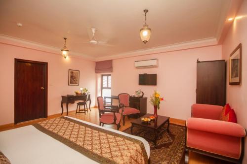 a bedroom with a bed and a living room at Amritara Suryauday Haveli in Varanasi