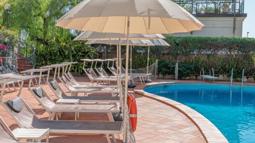 a group of chairs and an umbrella next to a pool at Bobby Executive in Sanremo