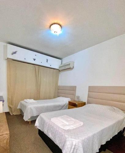 um quarto de hotel com duas camas e uma janela em Departamento Blanca em Mendoza