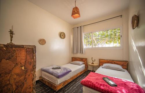 a bedroom with two beds and a window at Easy Going in Imsouane