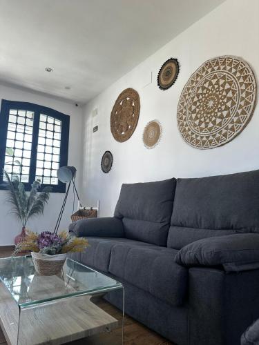 a living room with a blue couch and plates on the wall at Hotel Rural Irina in Badajoz