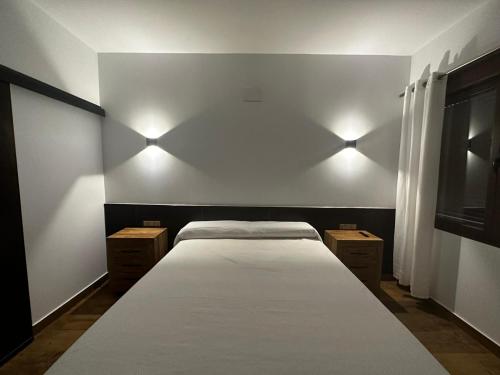 sypialnia z łóżkiem z oświetleniem na ścianie w obiekcie Hotel Rural Irina w mieście Badajoz