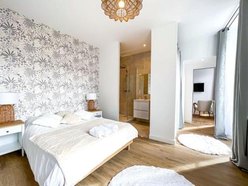 a white bedroom with a bed and a bathroom at Hyper-centre de Grenoble, suite parentale - wifi fibre - cocon in Grenoble