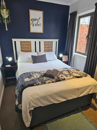 a bedroom with a large bed with a blue wall at @Galpin15 in Summerstrand