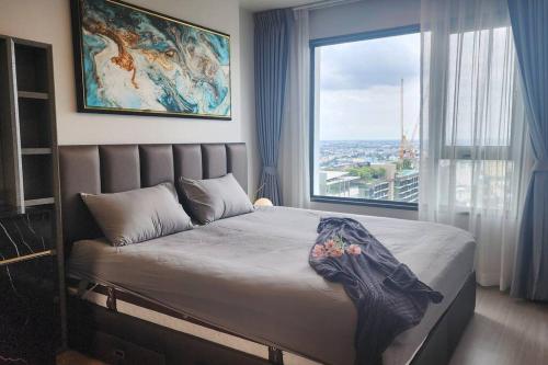 a bedroom with a bed with a large window at 1 BR plus@42th FL /2-3 min walk to BTS MRT Ladprao in Bangkok