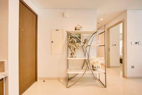 un pasillo con una estantería de cristal con jarrones. en Emaar Beachfront 2bdr Apartment on Beach Isle, en Dubái