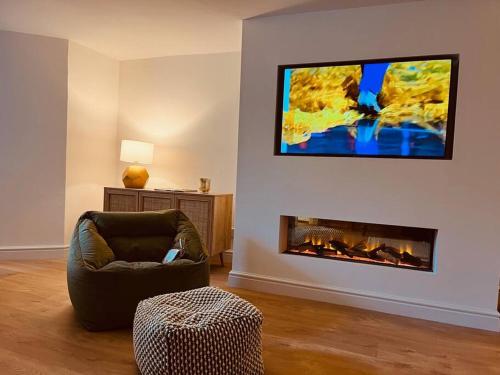 a living room with a chair and a fireplace at Chelston Grange Torquay Near the Beach with Private Garden & Parking in Torquay