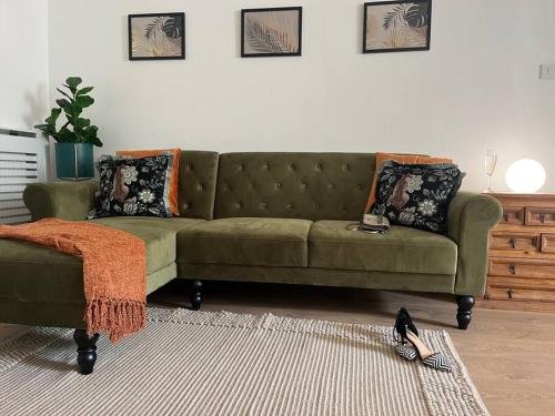 a green couch sitting in a living room at Chelston Grange Torquay Near the Beach with Private Garden & Parking in Torquay
