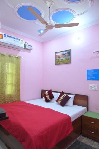 a bedroom with a bed with a red blanket and a ceiling at Sakshi ganga in Birbhaddar