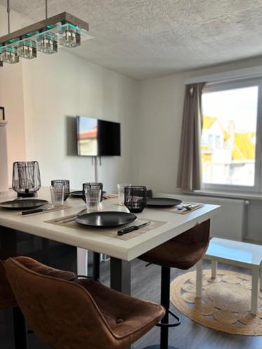 une pièce avec une table avec des chaises et une fenêtre dans l'établissement Belle époque à 5mn de la plage, à La Panne