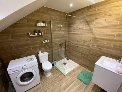a bathroom with a toilet and a washing machine at Studio Wood Vibe in Le Moule