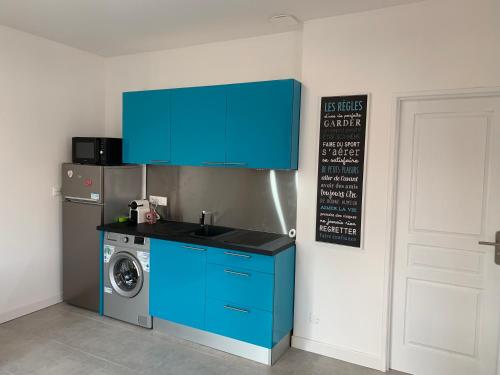 une cuisine avec un lave-linge et un meuble bleu dans l'établissement Room in Toulouse - T2 Toulouse Saint Martin du Touch, à Toulouse