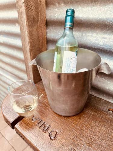 a bottle of wine in a bucket next to a glass at The Hide, Bouvard in Dawesville