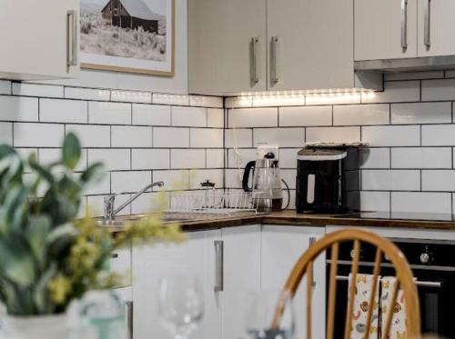 a kitchen with white tiled walls and a counter top at The Hide, Bouvard in Dawesville