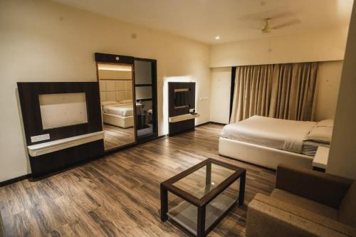 una camera d'albergo con letto e divano di The Four Seasons Recreation a Jālgaon