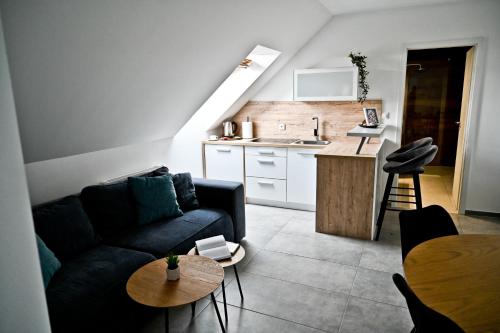 uma sala de estar com um sofá, uma mesa e uma cozinha em Apartment Lilly em Slivnica pri Mariboru