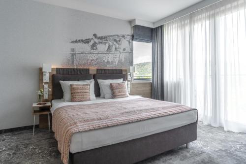 a bedroom with a large bed and a large window at Hotel Aquarion Family & Friends - Destigo Hotels in Zakopane