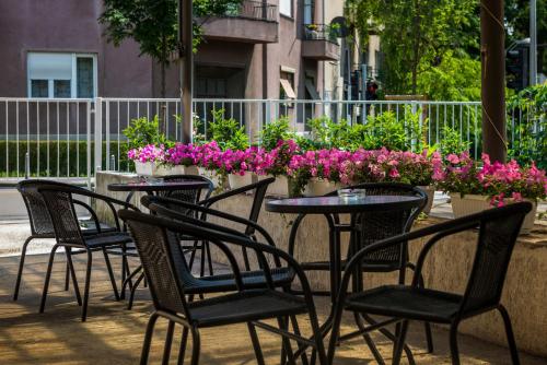 a group of chairs and tables with flowers on a patio at Rooms Lidija in Zagreb