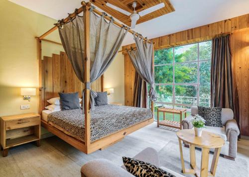 Casa Bhimtal في بهيمتال: غرفة نوم بسرير مظلة وغرفة معيشة