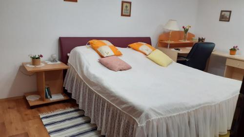 a bedroom with a bed with pillows on it at Berta Apartman in Senta